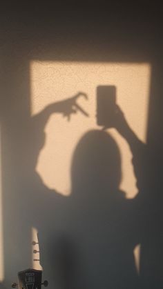 the shadow of a person holding a cell phone