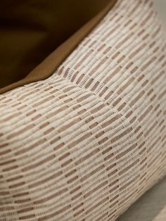 a brown and white pillow sitting on top of a bed