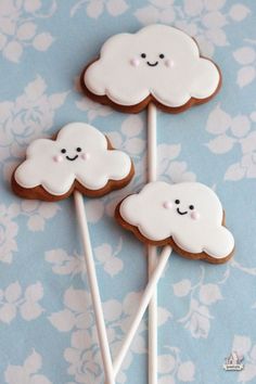 three cookies with white icing and smiling faces on them are sitting on top of each other