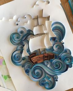 a paper cut out of a boat in the ocean with waves and clouds on it