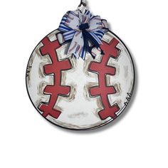 a red and white plate with crosses painted on the side, hanging from a hook