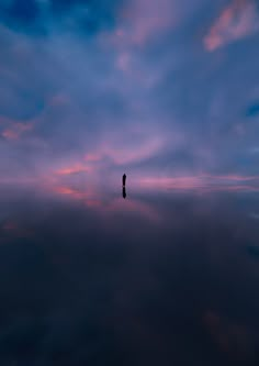 a person standing on top of a cloud covered sky