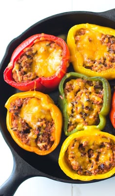 peppers stuffed with ground beef and cheese in a cast iron skillet