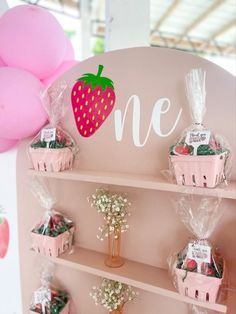 there is a pink shelf with baskets and strawberries on it