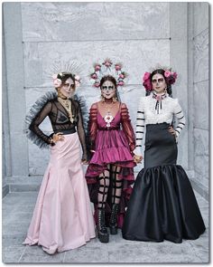 three women dressed up in costumes standing next to each other with their hands on their hips