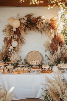 a table topped with lots of food next to tall grass and balloons in the air