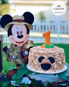 a mickey mouse birthday cake with the number one on it and an army themed cake topper