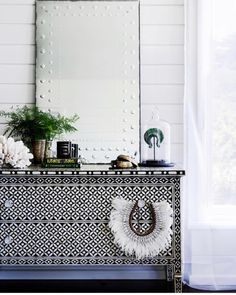 a black and white dresser with flowers on top