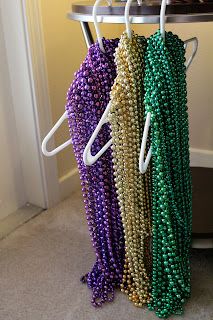 there are beads hanging on the rack in this room and one is purple, green, and gold