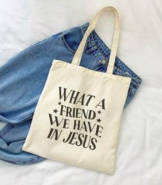 What A Friend We Have In Jesus Tote Bag DETAILS: Material: 100% cotton Heavy fabric (12 oz/yd² (406.9 g/m Reinforced stitching on the handles Durable Easy to carry Perfect for everyday wear DIMENSIONS: 15in x 16in 20in handles CARE INSTRUCTIONS: Do not iron directly over the printed area - print may stick to the iron Spot clean; do not bleach PLEASE NOTE: This item is printed on demand (made and shipped directly from a partnering manufacturer), so please allow 3-5 days for order processing before shipping. Apparel orders will not be packaged in Meli & Olive branding, which usually includes a thank-you card and a freebie sticker. Only orders for stickers, stationery, and keychains will come in our branded packaging, shipped directly by me (Ciara). If you're ordering both apparel and sticker Everyday Cotton Shoulder Bag With Letter Print, Cotton Shoulder Bag With Letter Print, White Cotton Shoulder Bag With Letter Print, Cotton Travel Bag With Letter Print, White Cotton Bag With Letter Print, Daily Use Cotton Canvas Bag With Letter Print, Eco-friendly Canvas Shoulder Bag With Letter Print, Eco-friendly Canvas Tote Bag With Letter Print, Everyday Cotton Bags With Letter Print