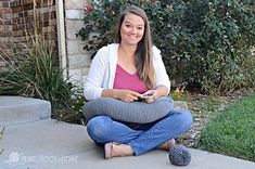 a woman sitting on the ground with her legs crossed