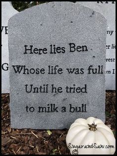 a white pumpkin sitting next to a grave with a poem on it's side