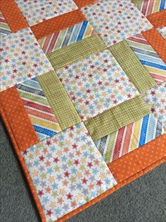 an orange and white quilt on the floor