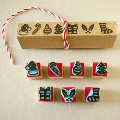 four rubber stamps with designs on them sitting in front of a cardboard box and string