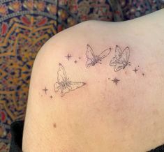 two butterflies on the back of a woman's shoulder, with stars in the background