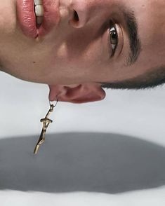 a man with his mouth open while holding a cross in front of his face and looking at the camera