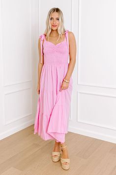 - Stroll through summer in this beautiful midi! With its adorable smocked bodice and sweet tied straps, it's an adorable piece of sunny style. Perfect for picnics, parties, or just feeling fabulous any day of the week! - Lightweight material - A built-in skirt lining - A sweetheart neckline with ruched detail - A smocked bodice - 1-inch tied straps - Functional side pockets - Flowy yet flattering silhouette that ends in a midi length hemline Pink Sundress With Smocked Back, Pink Sundress With Ruffled Straps For Beach, Cute Summer Sundress With Smocked Bodice, Pink Sundress With Ruffled Straps For Brunch, Pink Sundress With Ruffled Straps For Day Out, Summer Smocked Dress With Tie Straps, Cute Pink Smocked Dress With Smocked Back, Sleeveless Smocked Dress With Tie Straps For Summer, Cute Beach Sundress With Smocked Back