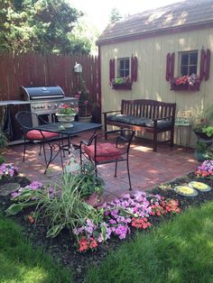 a backyard with flowers and patio furniture