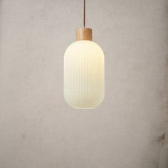 a white light hanging from a ceiling in a room with concrete walls and flooring