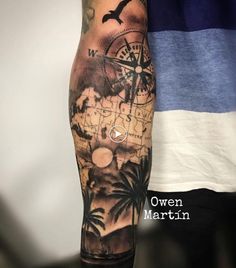 a man's arm with a compass and palm trees on it