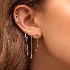 a woman wearing ear piercings with stars and moon charms