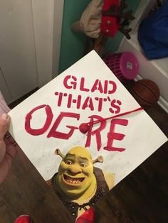 a person holding up a sign with the words glad that's ogre on it