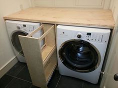 a washer and dryer in a small room next to a counter with an open door