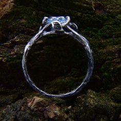 a silver ring sitting on top of a rock