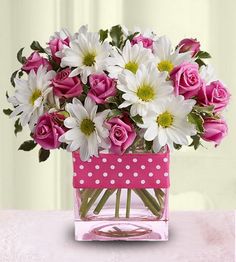 a vase filled with lots of white and pink flowers