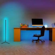 a desk with a computer on it next to a lamp and a chair in the room