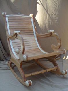 a wooden rocking chair sitting on top of a white sheet