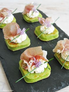 small appetizers are arranged on a black plate