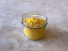 a jar filled with yellow powder sitting on top of a table