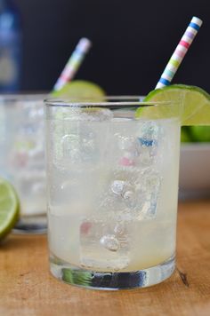 two glasses filled with ice and limes