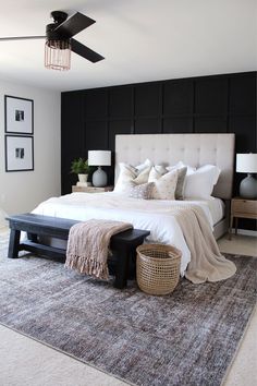 a bedroom with black walls, white bedding and gray carpeted area rugs