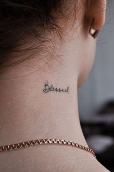 a woman with a tattoo on her neck that reads, be kindr and is wearing a chain around her neck