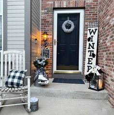 a white rocking chair sitting on top of a porch next to a black and white wreath