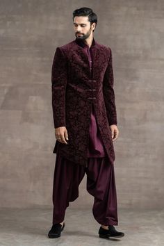 Wine etched velvet sherwani with frogging buttons. Paired with kurta and salwar.
Component: 3
Type Of Work: Floral
Neckline: Mandarin
Sleeve Type: Full
Fabric: Velvet
Color: Wine
Other Details: 
Floral print
Front buttons
Occasion: Sangeet,Groom - Aza Fashions Velvet Sherwani, Wine Colored Wedding, Sherwani For Men Wedding, Groom Dress Men, Salwar Pants, Sangeet Outfit, Tailored Fashion, Sherwani For Men, Wedding Sherwani