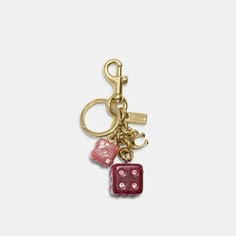 a pair of dice shaped keychains hanging from a gold - toned metal hook