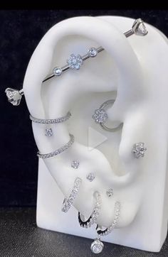 a white ceramic sculpture with rings on it's sides and diamonds in the middle