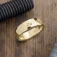 a close up of a ring on top of a wooden table next to a hammer