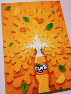 an orange card with a bottle of fanta in the center and green leaves on it