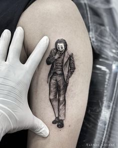 a man with a clown mask on his face is shown next to a tattoo artist's hand