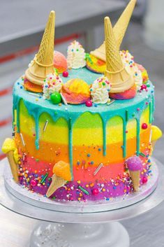 a colorful cake with ice cream and sprinkles on it sitting on a table