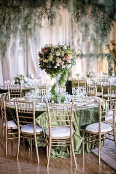 the table is set with green linens and floral centerpieces for an elegant wedding reception