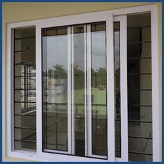 an open window on the side of a building with white trim and glass panes