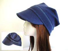 a mannequin's head wearing a blue hat on top of a wig