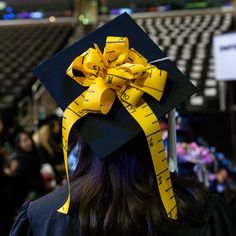 a person wearing a graduation cap with a yellow ribbon on it