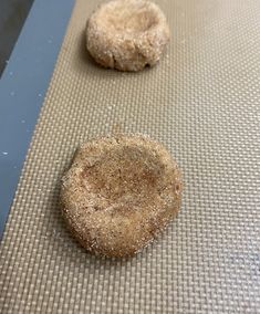 two sugar cookies sitting on top of a cookie sheet