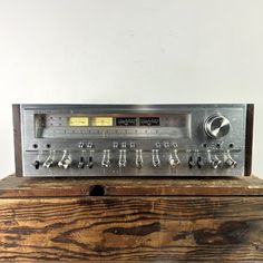 an old fashioned radio sitting on top of a wooden box with knobs and controls